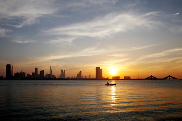 Fototapeta na wymiar Bahrain skyline and a moving boat