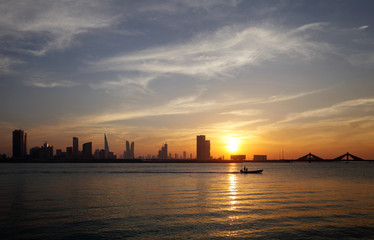 Obraz premium Bahrain skyline and a fishing boat