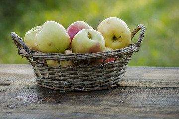 Fresh apples in a basket on table