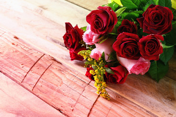 Beautiful bouquet of roses on wooden table