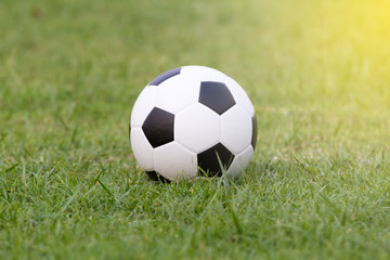 Fototapeta na wymiar Soccer ball and Football on grass at football stadium in the sun