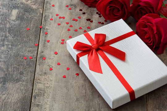 Gift box and red rose on wooden background.Valentines concept
