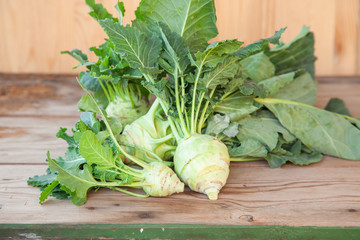kohlrabi cabbage with a tops of vegetable on a table, selective focus