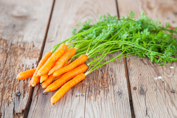 carrots with a tops of vegetable on a table, selective focus