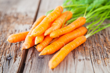 carrots with a tops of vegetable on a table, selective focus