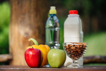 assorted fresh vegetables, peppers, apples, water and milk on wooden table. yoga, life concept, healthy eating  food.