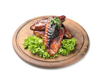 roasted turkey wings garnished with fresh green salad on the plate on white background