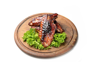 roasted turkey wings garnished with fresh green salad on the plate on white background