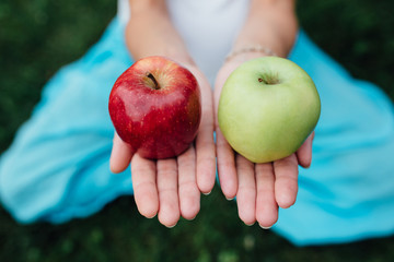 colorful picture of female hands with green and red apple.
