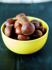 Fresh chestnuts in yellow bowl