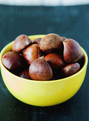 Fresh chestnuts in yellow bowl