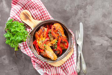 the baked chicken wings with a paprika and a thyme in a dish on a table, selective focus, the top view, copy space