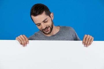 Handsome man holding a blank placard