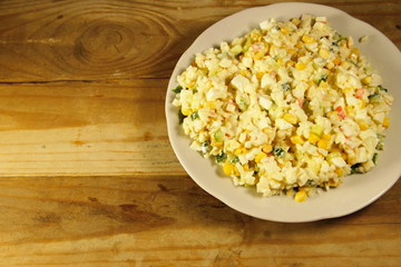 Salad with crab sticks, corn, cucumber, eggs and rice