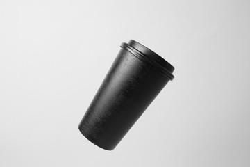Blank black paper cup in the air