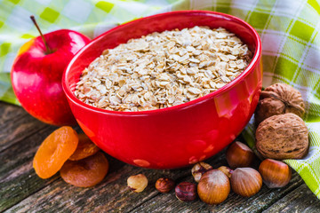 Oatmeal or oat flakes on dark wooden table