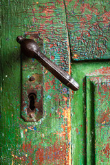 Color picture of an old doorknob on a green door, close-up - 132246807