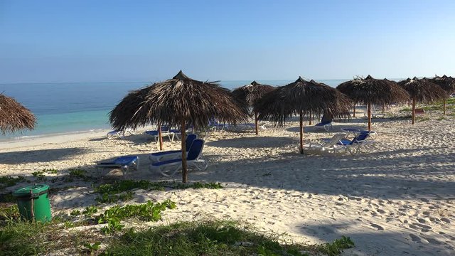 Empty sunbeds with parasols at the beach of the Cayo Levisa island. Cuba.