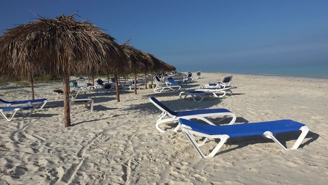 Empty sunbeds with parasols at the beach of the Cayo Levisa island. Cuba.