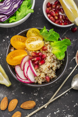 Vegetarian Quinoa bowl. Healthy breakfast or snack with detox , tomato, cucumber, carrot, pomegranate seeds, juicy blueberries and lettuce in portioned bowls. Top view