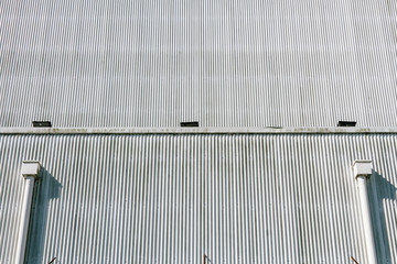 Wall of corrugated metal sheets and air ducts of a factory