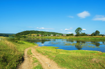 Obraz premium Rural landscape with village by the river