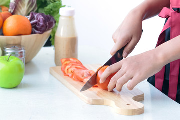 Close up of woman's chef hands cooking  vegetables salad in the