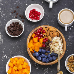 Fruit bowl buddha quinoa for a healthy modern breakfast. , blueberries, almonds, persimmons, red berries in  wooden . Top view.
