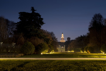 Night view of the Parco Sempione large central park in Milan, Italy. The Sforza Castle (Castello...