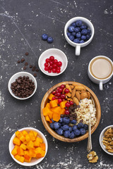Fruit bowl buddha quinoa for a healthy modern breakfast. , blueberries, almonds, persimmons, red berries in  wooden . Top view.