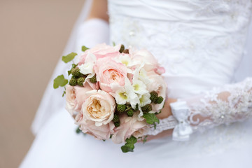 beautiful wedding bouquet of pink roses in bride's hands. Soft focus, selective focus