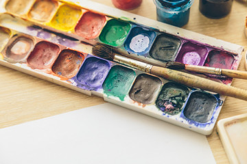 Brushes and paints on the table from the artist