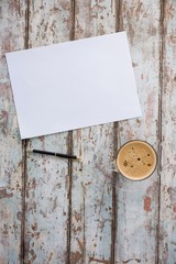 Cup of coffee with pen and paper