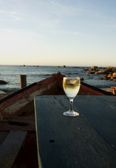 glass of white wine on the old boat at sunset, selective focus
