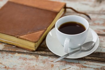 Cup of coffee with organiser on wooden table
