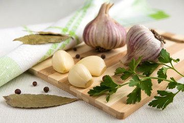 Fresh garlic, onion and spices on a light background closeup