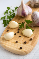 Fresh garlic, onion and spices on a light background closeup