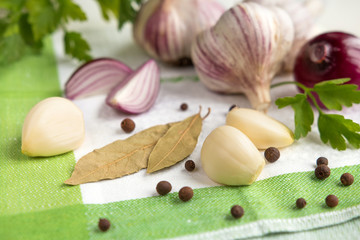 Fresh garlic, onion and spices on a light background closeup