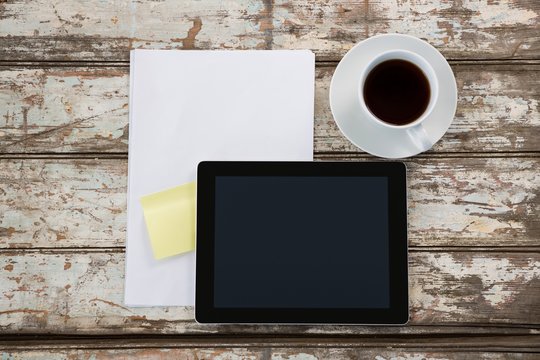 Digital tablet with blank paper and cup of coffee