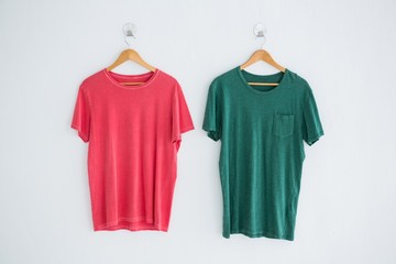 Pink and green t-shirts hanging on hanger