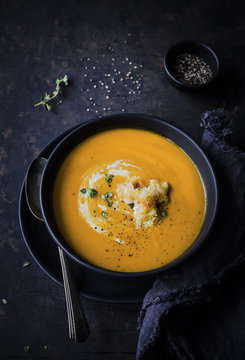 Spicy carrot ginger soup in a bowl on a tabletop