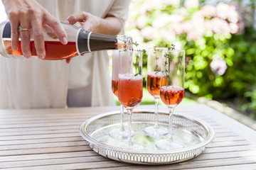 Woman pouring sparkling wine into four glasses