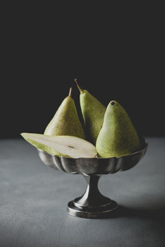 Still life of pears in tarnished silver bowl