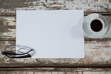 Coffee cup, blank paper and spectacles