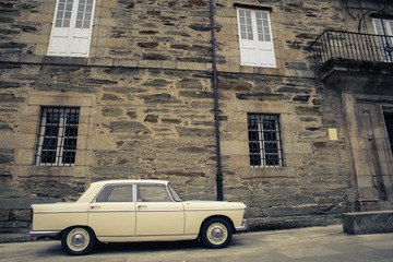 Fototapeta na wymiar Old antique car with stone wall in background