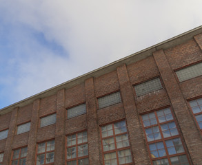 Obraz premium Old industrial building against a blue cloudy sky