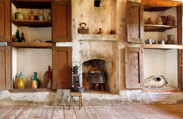 Obraz na płótnie Canvas Interior of old house in Georgia country, with kitchen utensils, kettle, primus, fireplace and wooden floor
