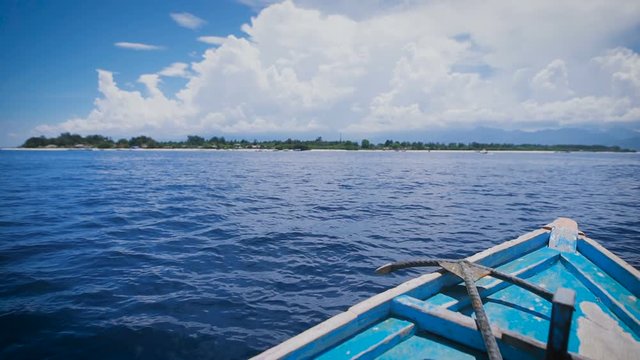 Ocean island of Bali. Boat tour. Young man in a boat on the ocean excursions. Stunningly clear ocean, year-round sunshine, paradise island - idyllic picture.