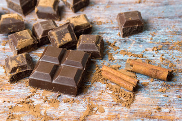 Chocolate on cocoa sprinkled table and cinnamon