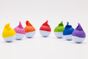 White golf balls with funny caps on the white background.
